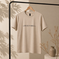 Beige t-shirt with 'The Beauty Bible Co.' logo on a hanger against a neutral background.